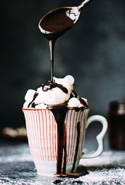 A striped cup with hot chocolate and marshmallows