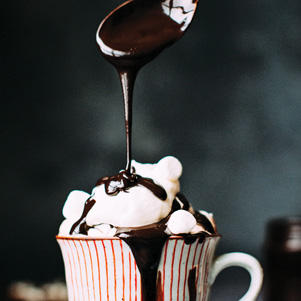 A striped cup with hot chocolate and marshmallows